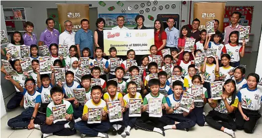  ??  ?? Nurturing the young: Lim (sixth from left) presenting the mock cheque to Goh (on Lim’s left) at SJK (C) Tun Tan Siew Sin. With them are Lim’s wife Karen (fifth from left), Chye Hoon (sixth from right), teachers and pupils with their copies of Step Up.