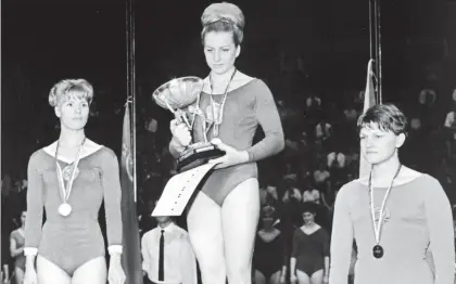  ??  ?? Vera, flanqueada por la medallista de plata Larissa Latynina, de la URSS (izquierda) y la alemana Radochia, durante la ceremonia de premiación del Campeonato Europeo de Gimnasia Artística, en mayo de 1965 ■ Foto Xinhua