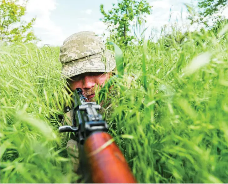  ?? ZUMA PRESS ?? Un soldado de Ucrania se esconde en la hierba en una operación cerca de Donetsk