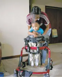  ?? KRISTEN ZEIS/STAFF ?? Asia Colbert demonstrat­es how her son Palmer, 2, uses a gait trainer for physical therapy. The family says Palmer’s acute flaccid myelitis, a rare illness similar to polio, was not documented by public health officials.