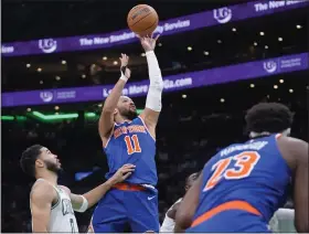  ?? STEVEN SENNE — THE ASSOCIATED PRESS ?? Knicks guard Jalen Brunson shoots next to Celtics forward Jayson Tatum, left, during the second half on Thursday in Boston.