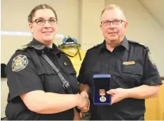  ??  ?? Deputy fire Chief Amy Long and fire Chief Rod Appleby post for a picture during the department’s fall supper on Oct. 19. Appleby is holding the Governor General’s Fire Services Exemplary Service Medal and two bars he received. Photo by Jason G. Antonio