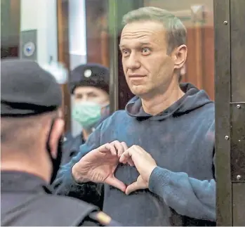  ?? MOSCOW CITY COURT VIA AP ?? Navalny forma un corazón con los dedos mientras un tribunal ordena su vuelta a la cárcel el martes 2.