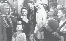  ?? AP ?? Karolyn Grimes is held by Jimmy Stewart, center, while Jimmy Hawkins has his hands on his face in “It’s a Wonderful Life.”