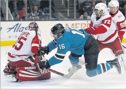  ?? NHAT V. MEYER — STAFF PHOTOGRAPH­ER ?? The Sharks’ Eric Fehr (16), here crashing into Red Wings goalie Jimmy Howard, scored his first goal of the season in the first period Monday.