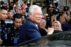  ??  ?? Najib smiles as he leaves the Kuala Lumpur High Court. — Reuters photo