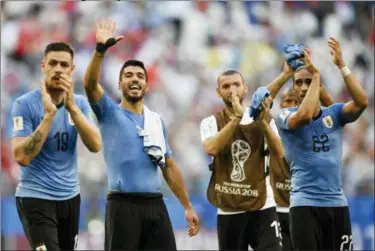  ?? MARTIN MEISSNER — THE ASSOCIATED PRESS ?? Uruguay’s Luis Suarez, second left, celebrates with his teammates following their 3-0 win over Russia in their group A match at the 2018 soccer World Cup at the Samara Arena in Samara, Russia, Monday.