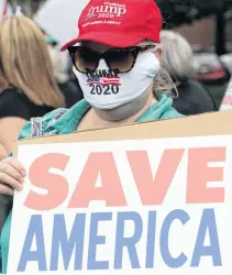  ?? REUTERS ?? A Trump supporter holds up a sign as demonstrat­ors participat­e in a Reopen Delaware rally in Dover, Delaware on May 1.