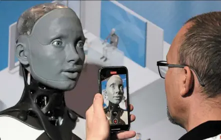  ?? - Photos: ap ?? a robot that looks like a human head designed by ameca interacts with visitors during the Internatio­nal Conference on Robotics and automation ICRA in London on May 30.