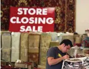  ?? Houston Chronicle ?? Employees catalog various oiental rugs as the owners of The Woodlands Oriental Rug Gallery prepare to close the doors to their 10,000 squarefoot gallery after 17 years in the area.