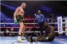  ??  ?? Fury knocks down Deontay Wilder in the fifth round. Photograph: Al Bello/Getty Images