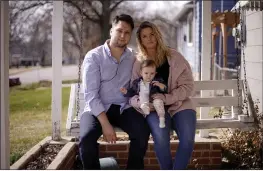  ?? CHARLIE RIEDEL — THE ASSOCIATED PRESS ?? Logan DeWitt with his wife, Mckenzie, and daughter Elizabeth sit on the front porch of their home Monday in Kansas City, Kan.