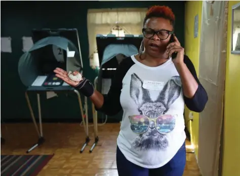  ?? Elizabeth Conley photos / Houston Chronicle ?? Election judge Amy McCan talks with the county clerk’s office about electrical problems at the Greater Love Missionary Baptist Church polling station on Election Day.