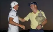  ?? WILFREDO LEE — THE ASSOCIATED PRESS ?? Justin Thomas, right, is congratula­ted by last year’s winner, Rickie Fowler, left, as he holds up his trophy after winning the Honda Classic golf tournament in a suddendeat­h playoff, Sunday in Palm Beach Gardens, Fla.