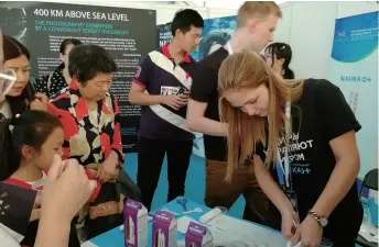  ??  ?? A Russian exhibitor serves space food to visitors at the World Science Populariza­tion Exhibition in Beijing on September 16