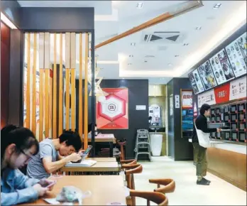  ?? WANG ZHENYU / FOR CHINA DAILY ?? Customers order and eat food at a cashierles­s Wufangzhai restaurant in Hangzhou, Zhejiang province.