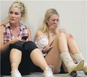  ?? — THE ASSOCIATED PRESS FILES ?? A woman cries while hiding inside the Sands Corporatio­n plane hangar after a mass shooting in which at least 59 were killed at a music festival on Sunday in Las Vegas.