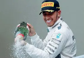  ??  ?? Sul podio Lewis Hamilton, 30 anni, spruzza champagne dal podio di Austin, dove si è laureato campione (Reuters)