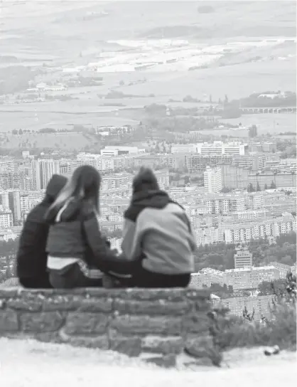  ??  ?? Un grupo de jóvenes, observando la cuenca de Pamplona desde el monte Ezkaba.