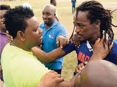  ??  ?? A teary-eyed coach Donovan Duckie (left) embraces Mount Pleasant Football Academy player Horace Sharpe, who scored the winning goal for his team against Barbican FC in the Magnum/Charley’s JB promotion play-off at the Barbican Complex in St Andrew...