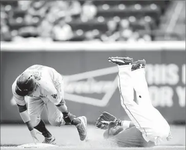  ?? Photograph­s by
Joe Robbins Getty Images ?? JUSTIN TURNER of the Dodgers is safe at second base and on his way to third after an error by Brandon Phillips of the Reds in the ninth inning.