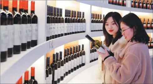  ?? LIU CHAN / XINHUA ?? Consumers choose red wine at the Chongqing Internatio­nal Exhibition and Trading Center in January.