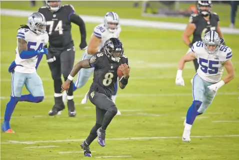  ?? NICK WASS/ASSOCIATED PRESS ?? Ravens quarterbac­k Lamar Jackson, center, runs with the ball while scoring a touchdown on a keeper against the Cowboys during the first half of Tuesday’s game in Baltimore. The Ravens won 34-17.