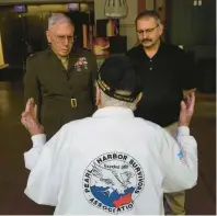  ?? War Conflicts. ?? Richard Schimmel, age 100, wears his Pearl Harbor Survivors Associatio­n jacket while talking to Frank Gunter, left, a retired U.S. Marine Corps Colonel and professor of economics at Lehigh University, and Steve Ondrusek, who was a chief warrant officer 4 during the Gulf