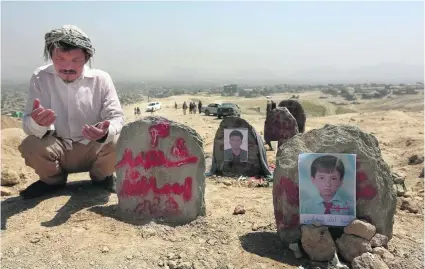  ?? Rahmat Gul / AP Photo ?? An Afghan prays at the graves of victims of Saturday’s bombing attack in Kabul yesterday.