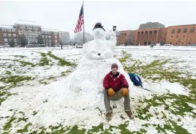  ??  ?? An MSU student sits next to Baked Bean the Snowman on the MSU Drill Field. (Photo by Cal Brown, SDN)