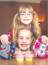  ?? Picture: Steve MacDougall. ?? Alana Henderson, bottom, with her 2 and 8 badges and her two birthday cakes, and her fiveyear-old sister Evie.