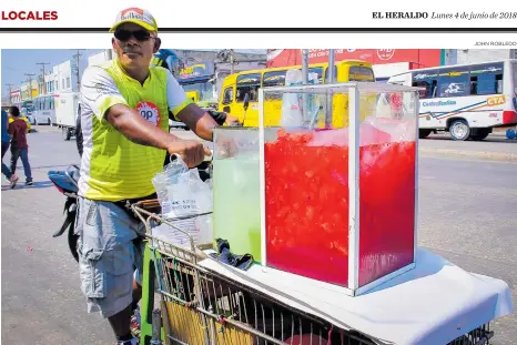  ?? JOHN ROBLEDO ?? Un hombre recorre la calle 30 vendiendo jugo de patilla y limonada, aprovechan­do la alta demanda por las altas temperatur­as.