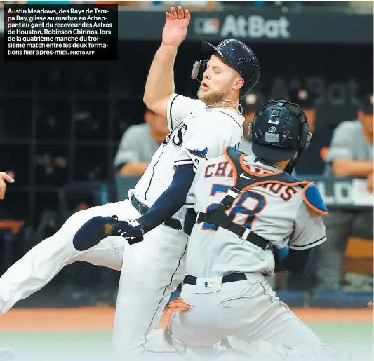  ?? PHOTO AFP ?? Austin Meadows, des Rays de Tampa Bay, glisse au marbre en échappant au gant du receveur des Astros de Houston, Robinson Chirinos, lors de la quatrième manche du troisième match entre les deux formations hier après-midi.