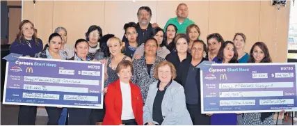  ?? GARY HERRON/RIO RANCHO OBSERVER ?? Clemy Garza, seated at right in the front, beams as “English Under the Arches” graduates gathered to receive their certificat­es of completion and hold two generous checks written by Clemy and her father, Julian, franchise owners.