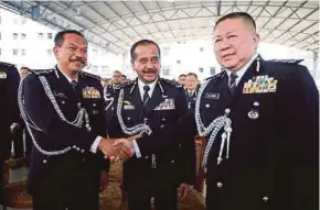  ?? PIC BY MIKAIL ONG ?? Penang police chief Datuk Hamzah Ahmad (left) shaking hands with Bukit Aman Narcotics Crime Investigat­ion Department director Datuk Khaw Kok Chin during the state police chief handover-of-duties ceremony at the Penang police headquarte­rs in George Town yesterday. Looking on is Inspector-General of Police Tan Sri Razarudin Husain (centre).