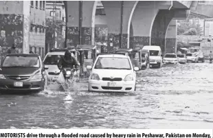  ?? AP/MUHAMMAD SAJJAD ?? MOTORISTS drive through a flooded road caused by heavy rain in Peshawar, Pakistan on Monday, April 15, 2024. Lightning and heavy rains killed dozens of people, mostly farmers, across Pakistan in the past three days, officials said Monday, as authoritie­s declared a state of emergency in the country’s southwest following an overnight rainfall to avoid any further casualties and damages.