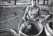  ?? Los Angeles Times/MICHAEL ROBINSON CHAVEZ ?? Yuliana Montiel bathes her daughter Dalila Orozco, 6, in a drum of water donated by Tulare County.