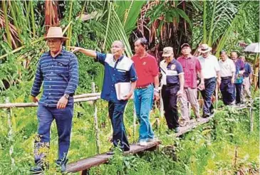  ??  ?? HENRY (kiri) melawat kawasan DUN Tasik Biru bagi mengenal pasti tahap kedaifan rumah penduduk.