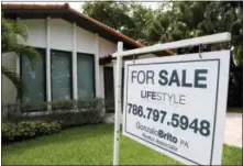  ?? LYNNE SLADKY — THE ASSOCIATED PRESS FILE ?? A sign hangs in front of a home for sale in Miami. The National Associatio­n of Realtors reported on sales of existing homes in September on Thursday.