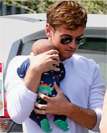  ??  ?? ‘Our precious son’: Daley carefully cradling his one-week-old baby Robbie Ray on Tuesday