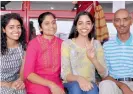  ?? PTI ?? CBSE Class 12 topper Raksha Gopal flashes the victory sign as she poses with her family in Noida on Sunday. —