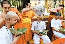  ?? PANUMAS SANGUANWON­G/GETTY-AFP ?? Members of "Wild Boars" soccer team shave their heads Tuesday in the Mae Sai district of Chiang Rai province. They will be ordained to become Buddhist novices Wednesday.