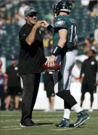  ?? MICHAEL PEREZ — THE ASSOCIATED PRESS ?? Eagles quarterbac­k Carson Wentz fist bumps with head coach Doug Pederson Sunday ... and that was before the two rookie team leaders helped engineer a blowout of the Pittsburgh Steelers at Lincoln Financial Field.