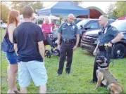  ??  ?? Montgomery Township Police officers Robert Johnson, center, and Dan Rose chat with attendees at the Souderton Community Night Out with police dog Odin nearby.