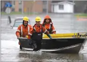  ?? Canadian Press photo ?? Hydro Quebec workers push a boat with equipment on Rue Saint-Louis in Gatineau, Que., as significan­t rainfall continues to cause flooding, on Friday.