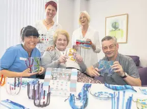  ??  ?? Charge nurse Carol Ritchie with patients June Morrison and Larraine Johnson, and (back left) artist Rachel Bower and (front) project coordinato­r Chris Kelly and some of the work on display. Picture by Angus Findlay