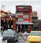  ?? AP ?? A man stands outside a restaurant after a storm moved through the area in Tulsa, Oklahoma. —