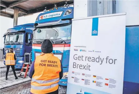  ??  ?? ► Funcionari­os distribuye­n informació­n sobre el Brexit a conductore­s de camiones en el puerto de Rotterdam.