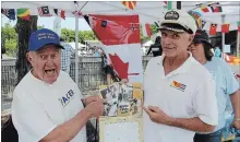  ?? ALLAN BENNER
THE ST. CATHARINES STANDARD ?? Dan Charkowy, left, and Tom Skrzeszews­ki reminisce about their neighbourh­ood, while looking through a calendar they were selling during the third annual Facer European Festival.