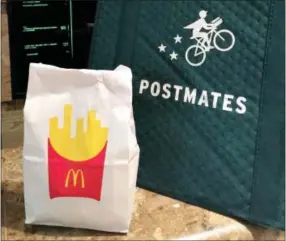  ?? CANDICE CHOI — THE ASSOCIATED PRESS ?? A bag of food from McDonald’s ordered through the Postmates service sits next to a Postmates delivery bag during a delivery in New York on Wednesday.